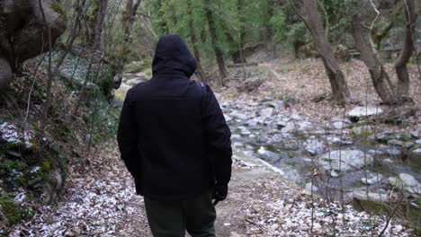 Male-hiker-alongside-river-creek-mountain-mountain-forest