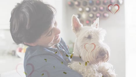 Animation-of-hearts-and-confetti-over-caucasian-woman-with-her-pet-dog