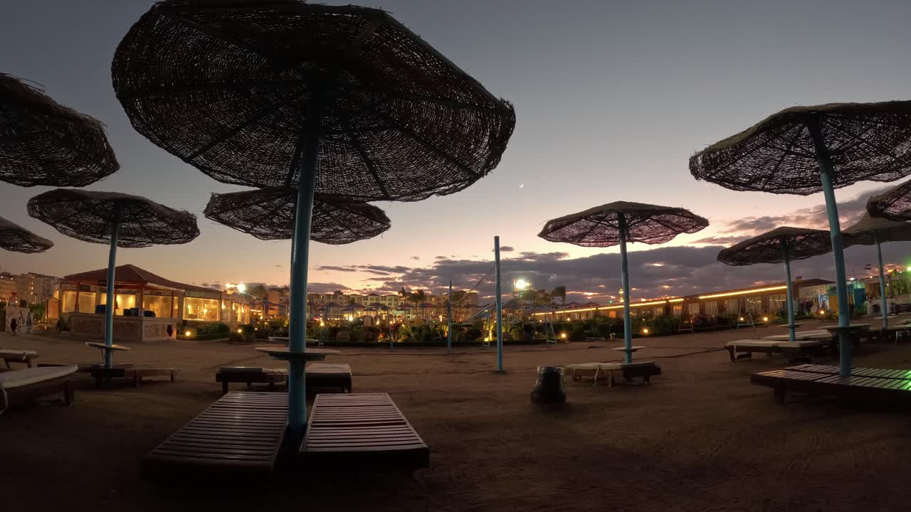 lapso de tiempo de la puesta de sol en la playa con sombrillas y sillas de playa con piscina de fondo de playa de mar con una vista increíble de la puesta de sol