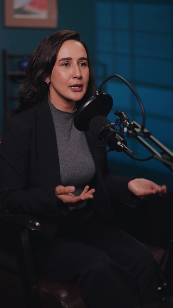 Professional Woman Speaking into Microphone in Studio Setting