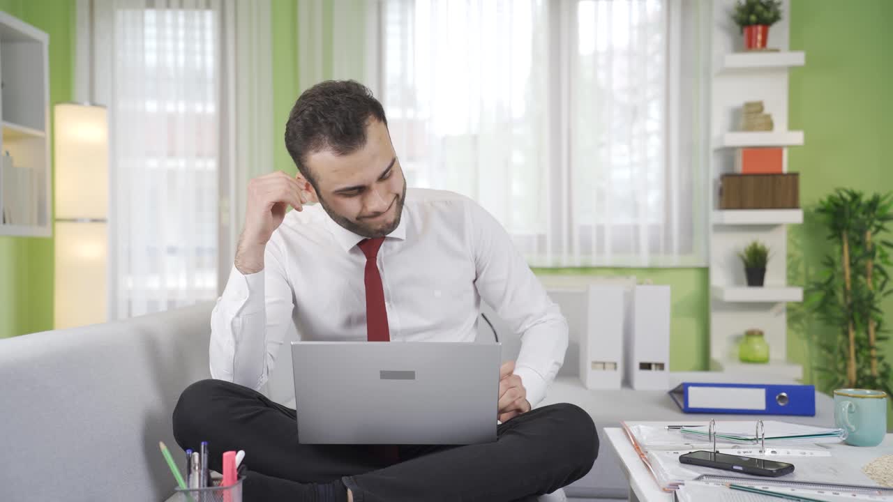 스트레스를 받은 남자가 노트북을 보고 재정 문제에 대해 걱정하고 있습니다.