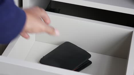 man opening drawer and retrieving wallet