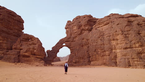 traveling nomad backdropped by elephant-shaped rock formation at sunrise