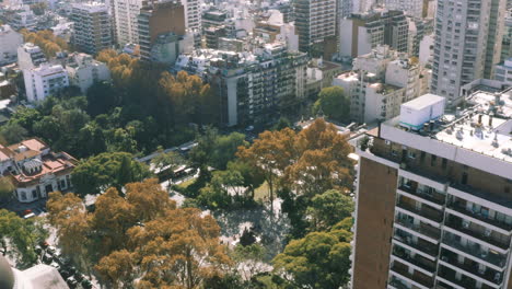 AERIAL---Plaza-Manuel-Belgrano-park,-Buenos-Aires,-Argentina,-forward-tilt-down