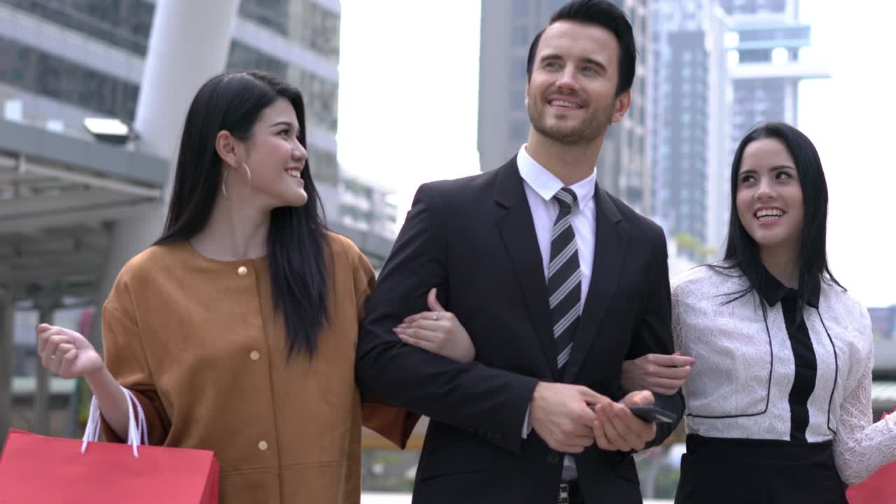 hombre guapo lleva a la mujer a comprar juntos en la ciudad. dama con bolsa de compras en las manos.