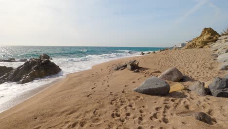 Schöner-Mediterraner-Sandstrand,-Maresme-Barcelona,-San-Pol-De-Mar,-Mit-Felsen-Und-Ruhigem-Meer-Und-Türkis,-Costa-Brava,-Calella-De-Mar