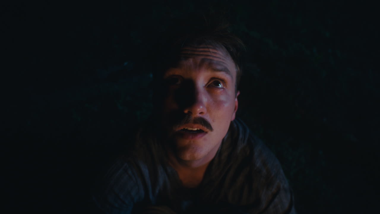 People by a campfire at night, illuminated by warm light