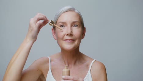 mature woman applying foundation