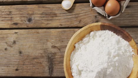 video of bowl with flour and eggs on wooden surface