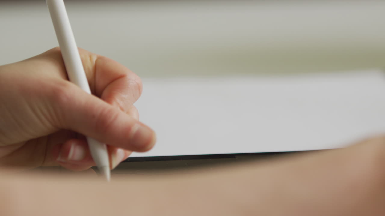 Womans hand drawing on an iPad whilst using a stylus