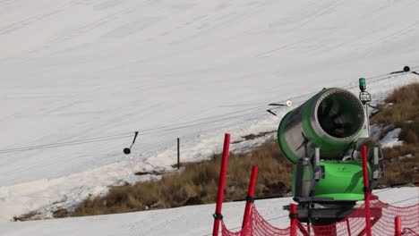 snow making machine on side of a ski slope, artificial snow