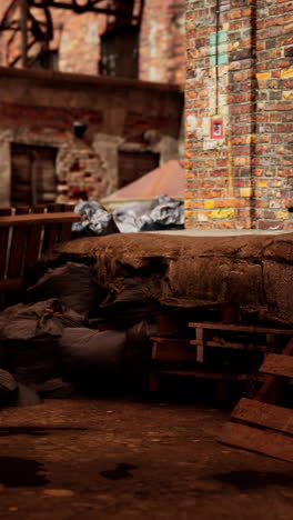 un callejón sucio detrás de un antiguo edificio industrial con paredes de ladrillo y un pallet en el suelo