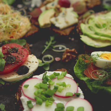 assortment of home made sandwiches with various toppings  with colorful fresh vegetables