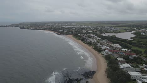 Meer-An-Der-Küstenstadt-Am-Strand-An-Einem-Bewölkten-Tag-In-Bundaberg,-Queensland,-Australien---Drohnenaufnahme-Aus-Der-Luft