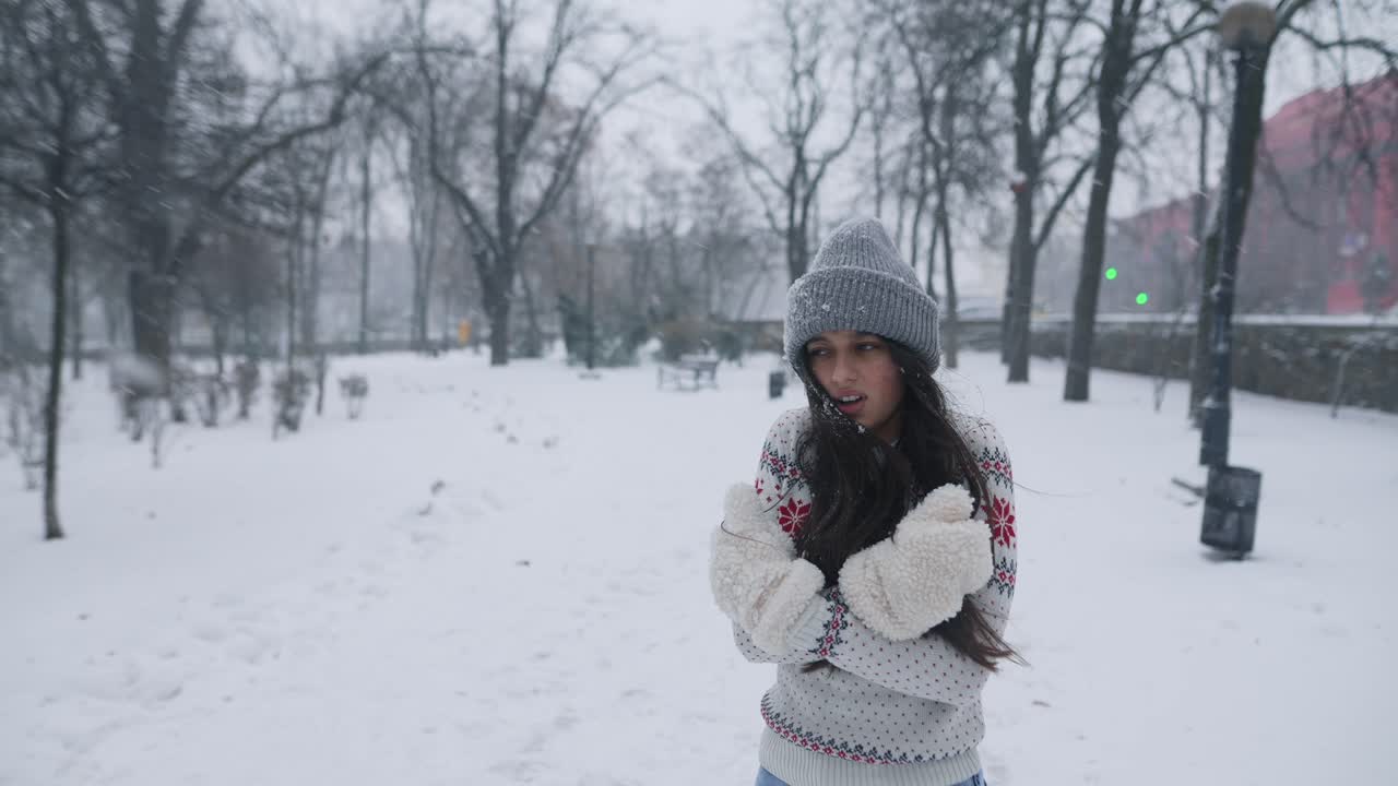 공원에서 눈이 내리는 날을 즐기는 여자