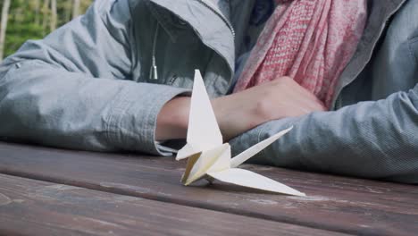 just finished origami paper swan, closeup with girl in a background