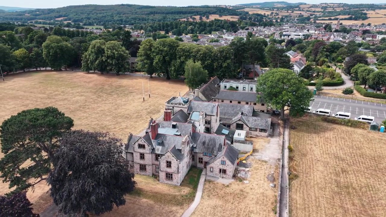 Scuola di Ruthin dopo la chiusura appena annunciata - drone che ruota da lontano, Galles del Nord - Agosto 2026.