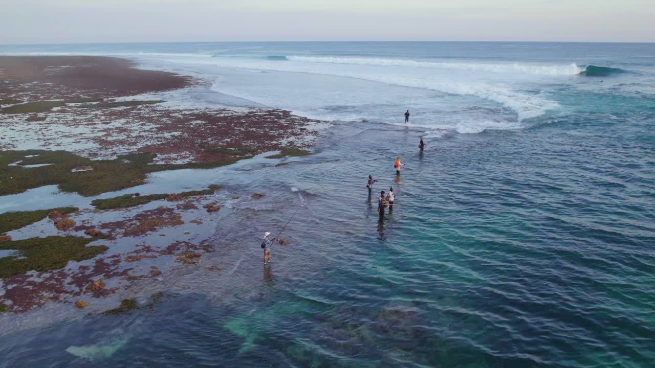 Rybacy z Bali łowiący ryby na wybrzeżu oceanu w Uluwatu w Indonezji, ujęcie z lotu ptaka