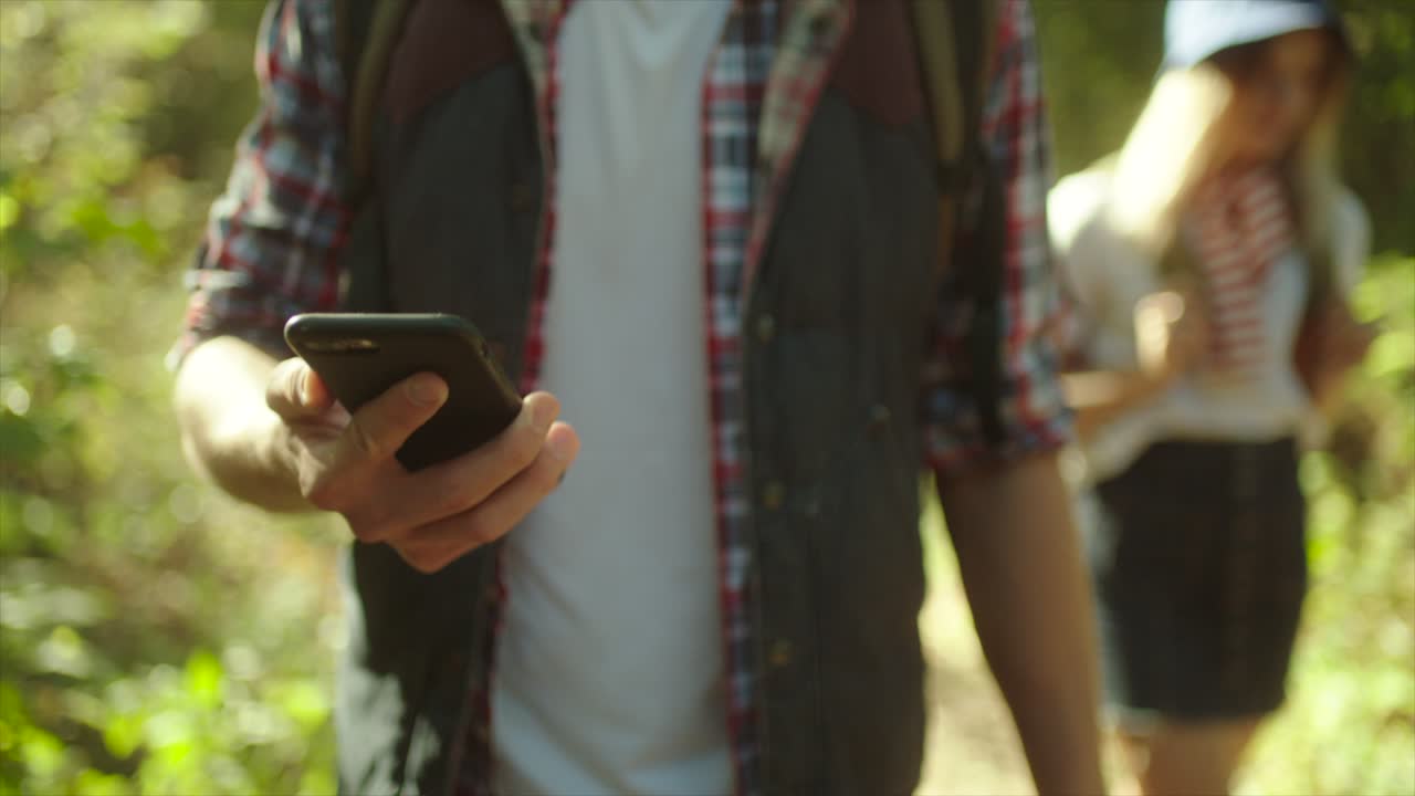 mochileros usando google maps en el teléfono inteligente en su ruta en el bosque durante el senderismo