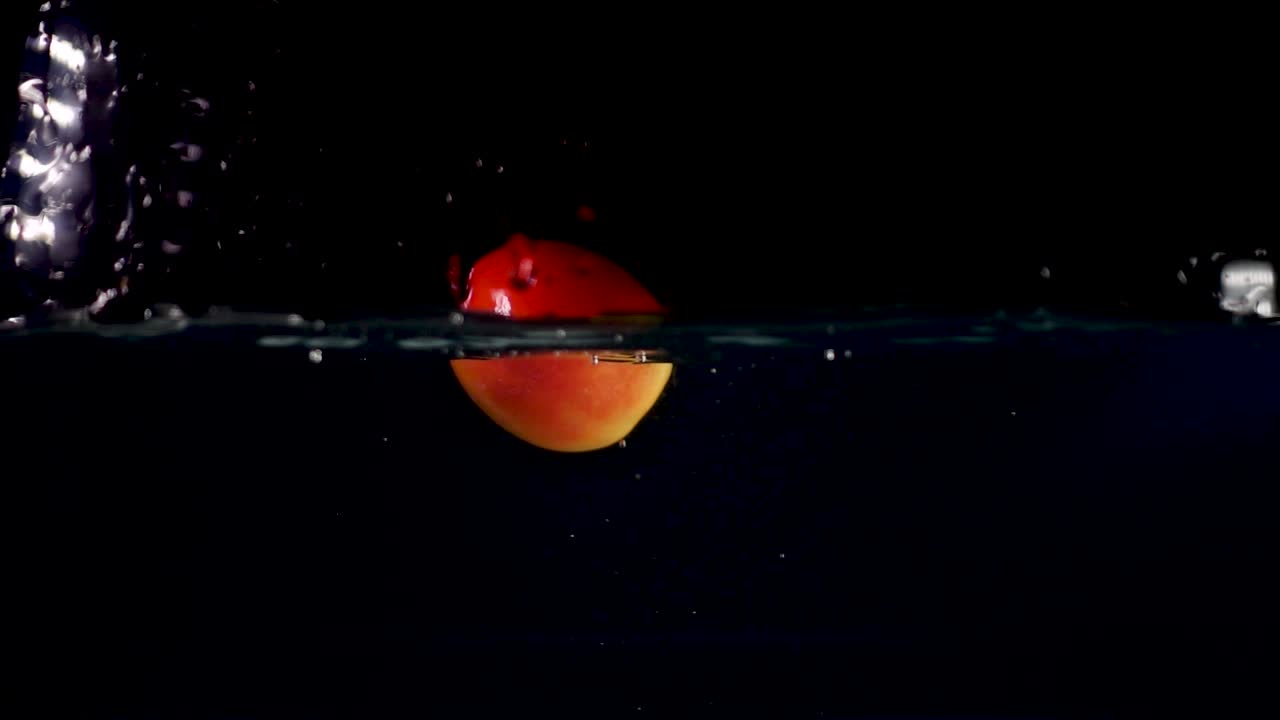 video inverso en cámara lenta de 500 fps de un tomate rojo salpicando en el agua