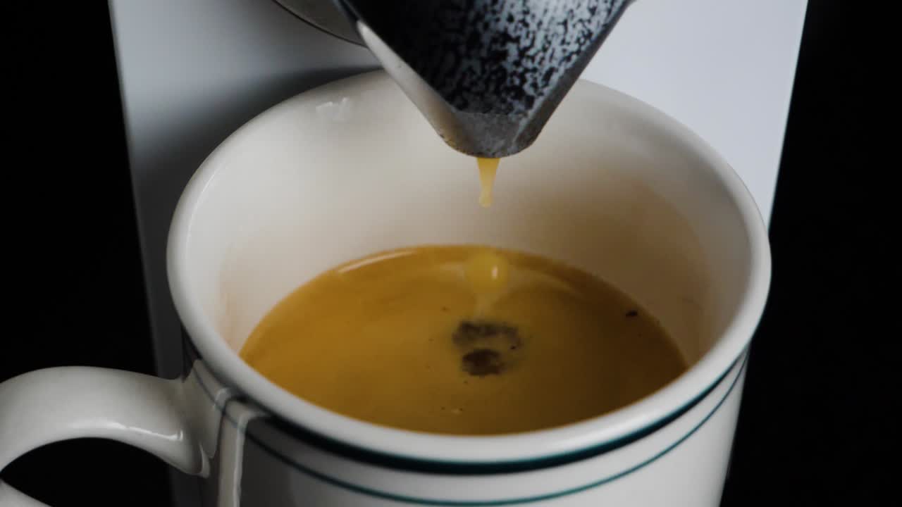 Close up of a coffee machine dropping coffee in a mug