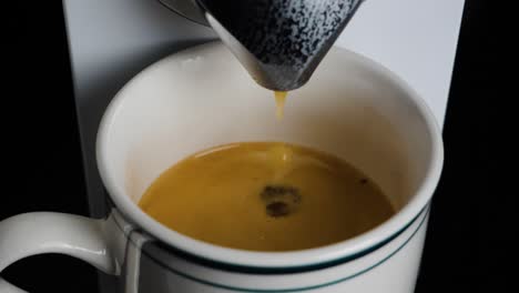 close up of a coffee machine dropping coffee in a mug