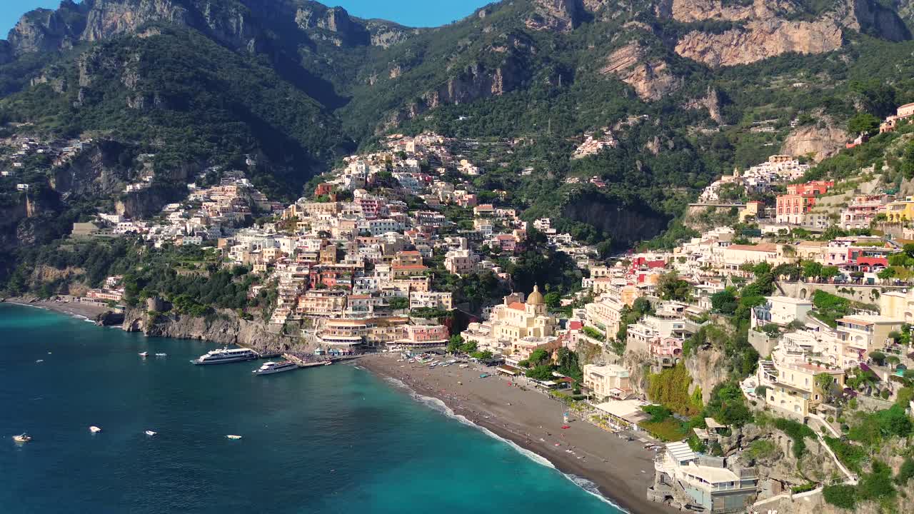 Panoramica aerea di Positano, borgo sulla Costiera Amalfitana, circondato dal mare blu con yacht e barche