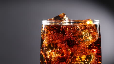 glass of cola. ice cola with splashing bubbles slow motion.