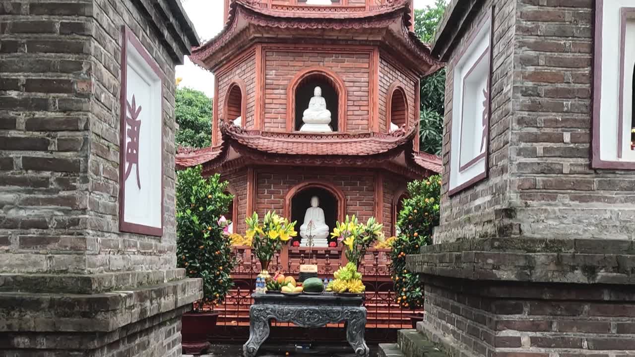 Detailed look at pagoda architecture with statues and intricate brickwork.