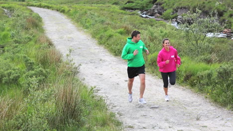 fit couple jogging together on a trail