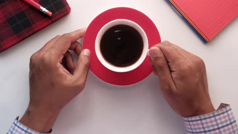 persona bebiendo café en su escritorio.