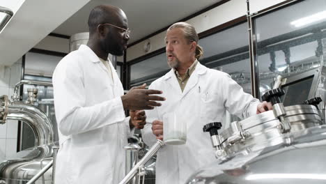 wissenschaftler sprechen drinnen mit dem produkt in der hand