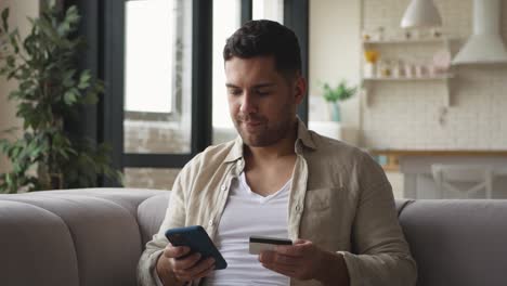 man shopping online on his smartphone and paying with credit card