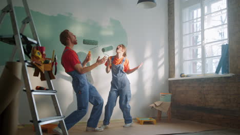 active family singing with rollers during house renovation in new apartment.