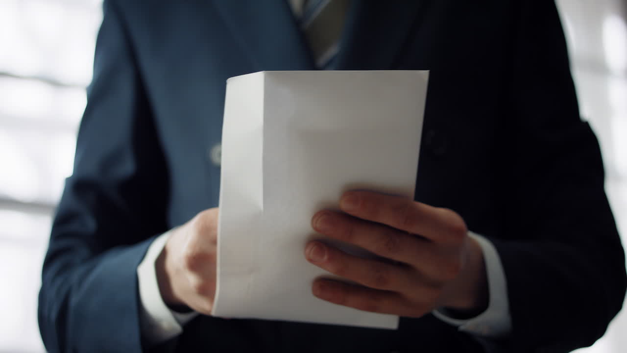 Man putting cash envelope close up. Businessman holding pack of euro bills.