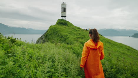 woman hiking to lighthouse on a cloudy day