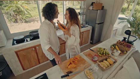 couple enjoying a papaya breakfast in a tropical kitchen