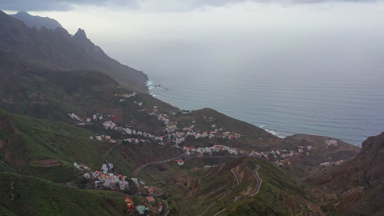 un pequeño pueblo de montaña en la costa atlántica de la isla de tenerife con los afilados picos de las montañas distantes escondidos en nubes tormentosas