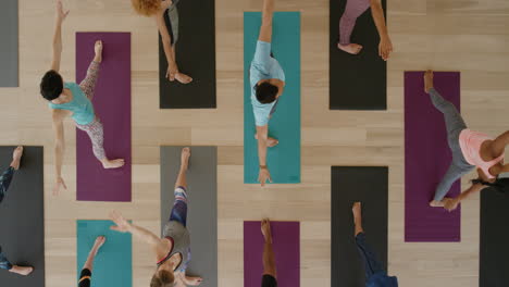 Vista-Superior-De-La-Clase-De-Yoga-De-Jóvenes-Sanos-Practicando-Pose-Triangular-Estirándose-Disfrutando-Del-Estilo-De-Vida-Físico-Haciendo-Ejercicio-En-El-Estudio