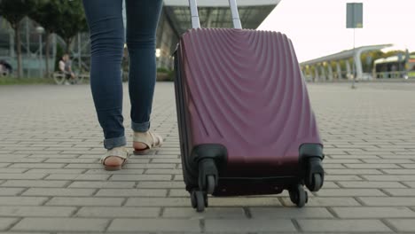 businesswoman tourist walking with luggage. walk down the street with suitcase bag on wheels