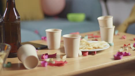 mesa de fiesta vacía con confeti y bebidas