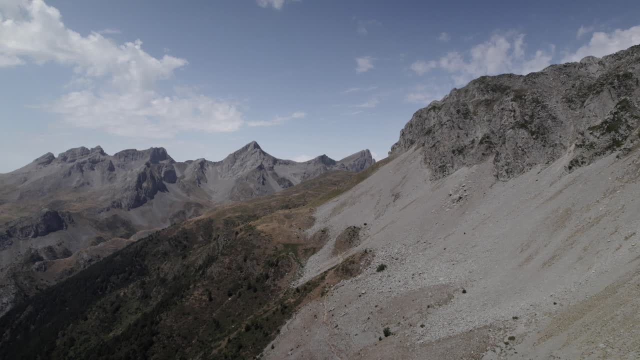 4K low-altitude drone shot over the Western Valleys Natural Park in the Aragonese Pyrenees, Spain. A cinematic aerial view of the mountain trail leading to Ibón de Acherito.