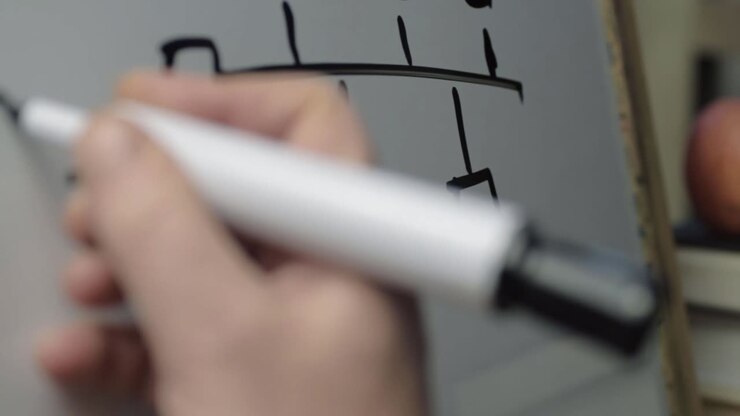 Hand writing diagram on whiteboard panning shot