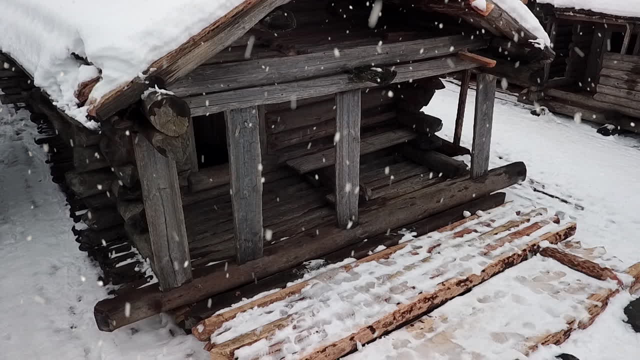 눈이 내리는 동안 두꺼운 눈으로 덮인 유서 깊은 목조 건물, 공중 하강 전망