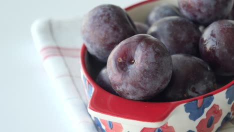 stack of plums in a bowl on white background ,