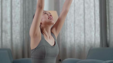 retrato de cerca de una joven atleta asiática haciendo ejercicio, estirándose y practicando yoga en casa. estilo de vida saludable, fitness, bienestar y concepto de atención plena
