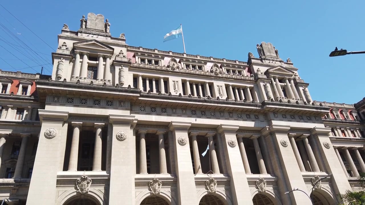 Angolazione bassa del Palazzo di Giustizia con bandiera argentina a Buenos Aires, Argentina
