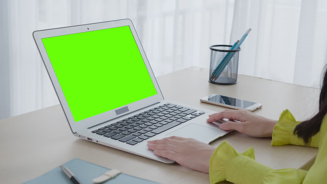 joven mujer de negocios asiática trabajando en una computadora portátil con maqueta de pantalla verde en casa, llamada de video de mujer de negocios y hablando en línea, exhibición de portátil con llave de croma, concepto de comunicación.