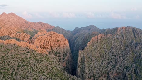 Bergmassiv-Im-Orangefarbenen-Licht-Des-Untergehenden-Sonnentals,-Drohnen-Luftaufnahme