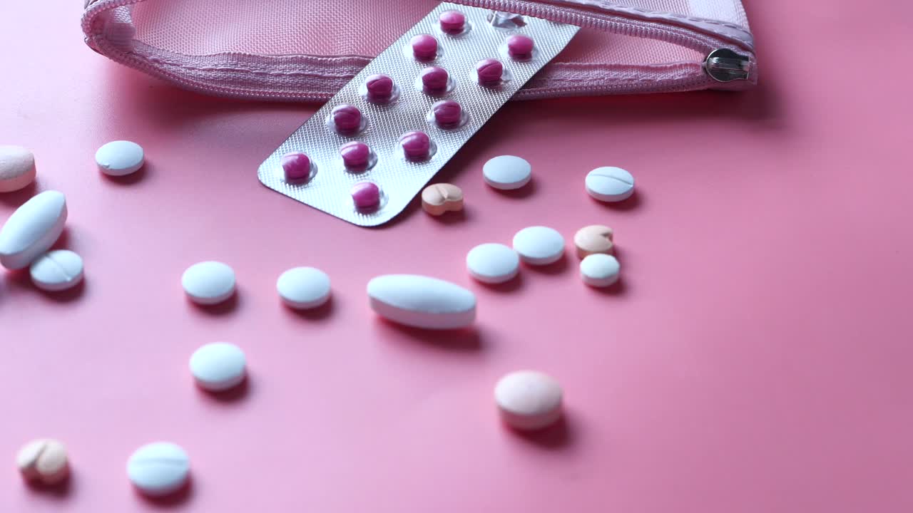 Pastillero rosa con medicamentos